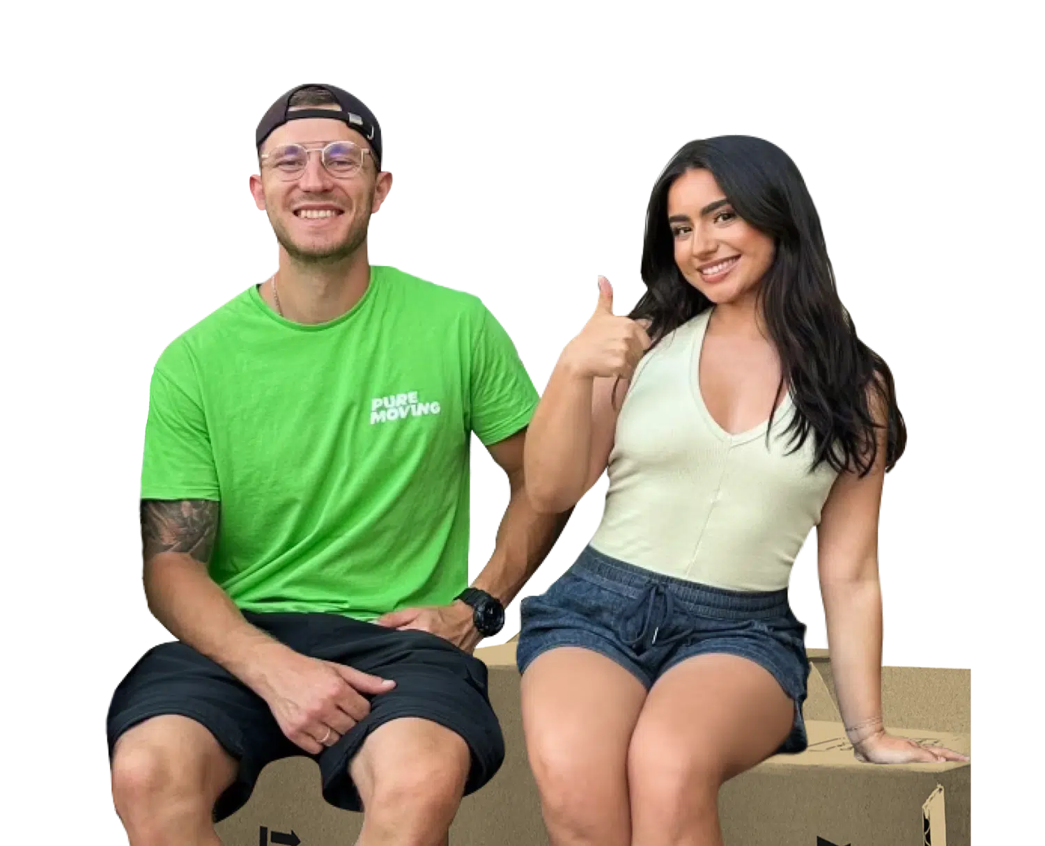 A man in a green shirt and glasses sits beside a woman in a white top and shorts. She gives a thumbs-up gesture while both smile.